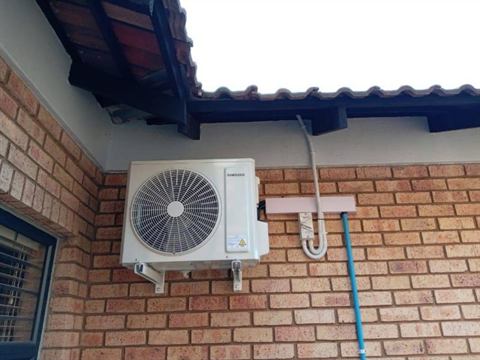 Outdoor unit on the face-brick wall of a home