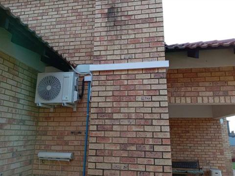 Outdoor unit on the face-brick wall of a home