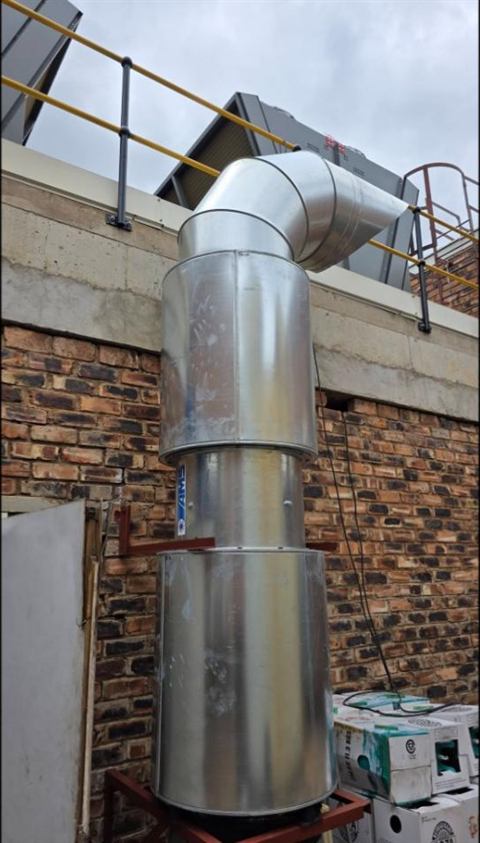 Exhaust stack against a face-brick wall