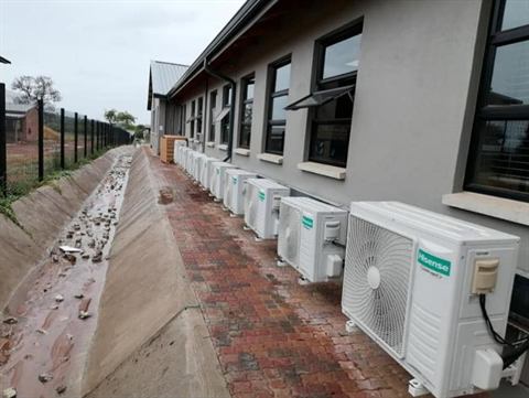 Long row of outdoor condensers along a school building