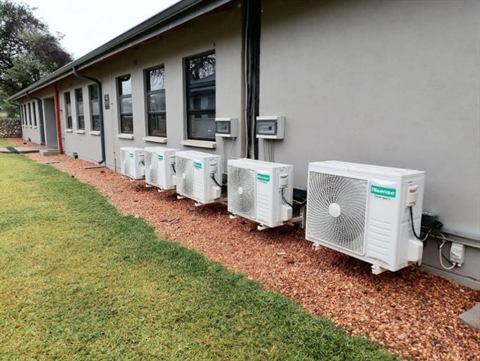 Row of outdoor condensers along a building