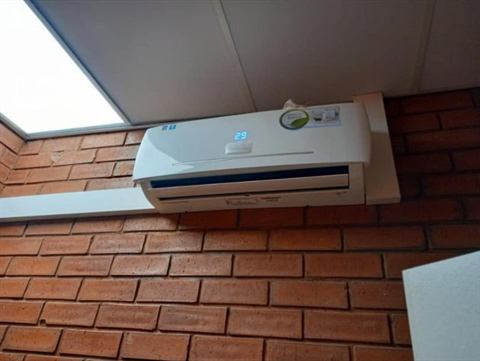 Wall-mounted split unit on a face-brick wall