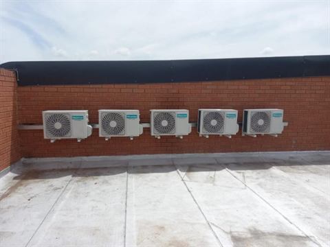 Five outdoor condensers on a parapet wall