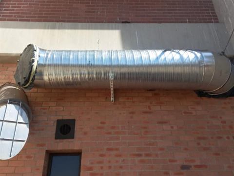 Spiral ducting on an external brick wall